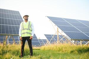 Young African American engineer in a field of solar panels. photo