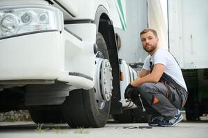 Professional truck mechanic working in vehicle repair service. photo