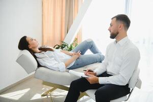 Male doctor and female patient at therapy session photo