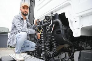View of a driver connecting the power cables to trailer of a commercial truck photo