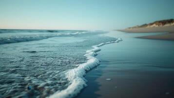 Foamy Ocean Waves Crashing on Sandy Shore at Sunset photo
