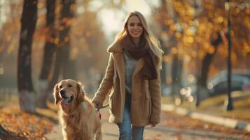 Woman Walks Golden Retriever Through Autumn Park photo
