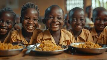 Smiling African Children Enjoying a Meal Together in a Classroom photo