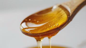 Golden Honey Dripping From A Wooden Spoon In Bright Natural Light. photo