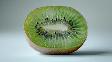 Freshly Cut Kiwi Fruit Showing Vibrant Green Flesh and Tiny Black Seeds on White Background. photo