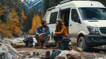 Adventurous Couple Enjoying Autumn by Their Van Near Serene River in Mountain Landscape photo