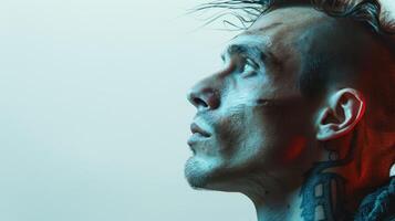 Intense Portrait of a Tattooed Man in Profile Bathed in Soft Blue and Red Light Against a Gradient Background photo
