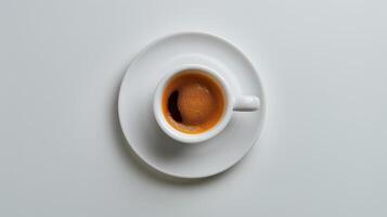 A Perfectly Brewed Espresso on a White Saucer in a Cozy Coffee Shop Setting photo