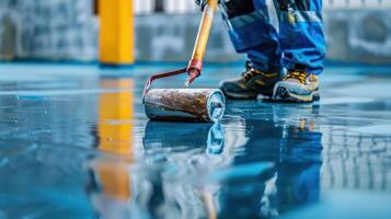 Skilled Worker Applying Glossy Finish to Floor in Modern Industrial Setting During Daylight Hours photo
