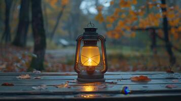 Warm Lantern Illuminates Wooden Table Amidst Autumn Leaves in Tranquil Forest Setting at Dusk photo