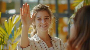 Smiling Young Woman Joyfully Waving in a Bright Indoor Setting Surrounded by Lush Greenery photo