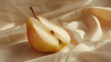 Sliced Pear Glowing in the Soft Light on Delicate Fabric Background photo
