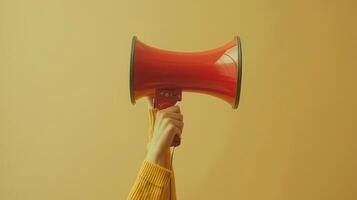 Vibrant Red Megaphone Raised High Against a Warm Yellow Background During a Passionate Public Speech photo