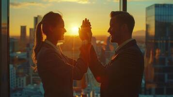 Silhouetted Couple Engaged in Playful Interaction Against a Stunning Sunset in a Modern City photo