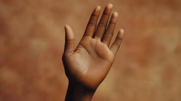 Hand Raised Against Warm Background Signifying Openness and Communication During Late Afternoon Light photo