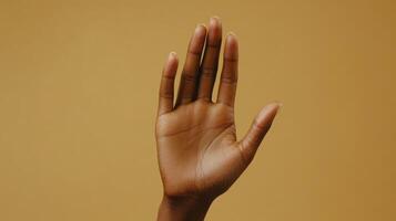 Open Hand Gesture Against Warm Beige Background During Daylight Hours photo