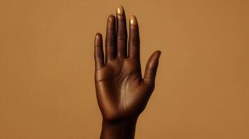Hand Raised Against Beige Background Demonstrating Gesture of Communication and Expression photo
