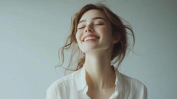 Joyful Young Woman Smiling Brightly Against Simple Background in Natural Light photo