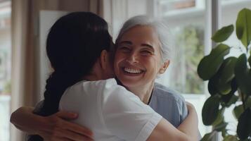 Two women share a joyful hug filled with warmth and love in a bright room photo