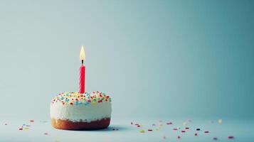Colorful Birthday Cake With Candle and Sprinkles on Light Blue Background photo