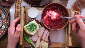 Traditional Ukrainian dish Borscht. Eating red Ukrainian borscht from first person POV. A hand stirs the first course of beetroot with a spoon. video