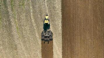 Aerial top view A tractor plows a field with a plow. Preparation of the field for wintering video