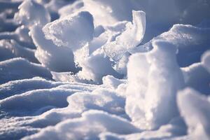 Melting snow and ice surface close up in evening sunlight in wintertime photo