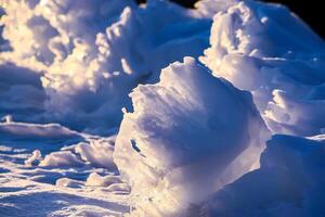 Melting snow and ice surface close up in evening sunlight in wintertime photo