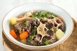 Indonesian Oxtail Clear Soup or Sop Buntut with Potato and Carrot photo