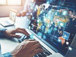 Programmer working with laptop and hologram of social media icons and world map photo