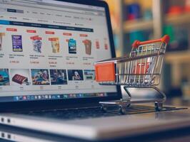 Miniature shopping cart standing on laptop keyboard showing online shop photo