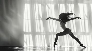 Young female dancer rehearses a dance routine in a well lit studio photo