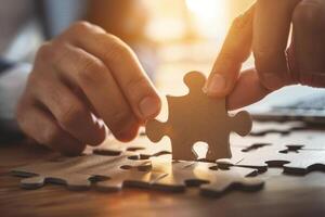 Businessman is holding a puzzle piece over a table, concept of solution and problem solving photo