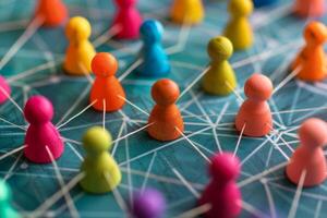 Colorful wooden pawns interconnected with white threads, symbolizing networking and cooperation photo
