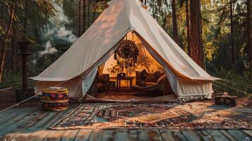 Spacious canvas bell tent shines in the forest at sunset photo