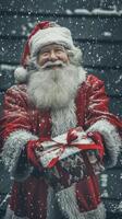 Santa claus holding christmas present smiling during snowfall photo