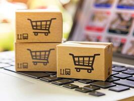 Cardboard boxes with shopping cart logo on laptop for online shopping concept photo
