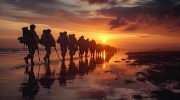 Army soldiers line walking on beach at sunset photo