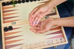 Hands holding dice over backgammon board, preparing to play a game photo