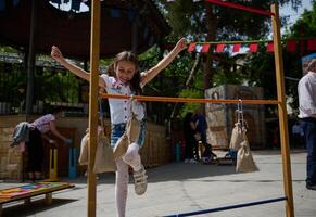 Young girl enjoying outdoor festival game with burlap sack obstacles on a sunny day photo