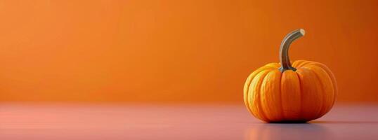 Vibrant Orange Pumpkin on White Surface Against Bright Orange Background in Autumn photo