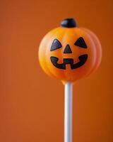 Halloween Cake Pops With Pumpkin Decorations Against Orange Background photo