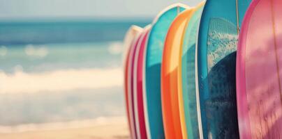 Colorful Surfboards Lined Up on a Beach Shore by the Waves in Bright Sunlight photo