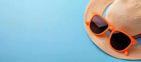 Summer Accessories With Orange Sunglasses And Straw Hat On Turquoise Background photo