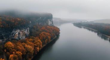 Autumn River View With Mist Over Cliffs and Colorful Trees in the Valley photo