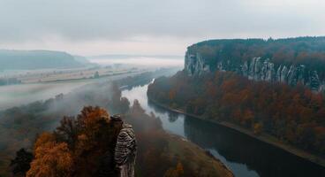 Autumn River View With Mist Over Cliffs and Colorful Trees in the Valley photo