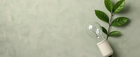 Eco-Friendly Lightbulb With Leaves Against a Green Background photo