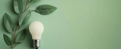 Eco-Friendly Lightbulb With Leaves Against a Green Background photo