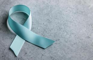 Light Blue Awareness Ribbon on Gray Surface photo