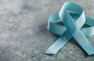 Light Blue Awareness Ribbon on Gray Surface photo